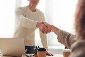 Man shaking hands with woman in office